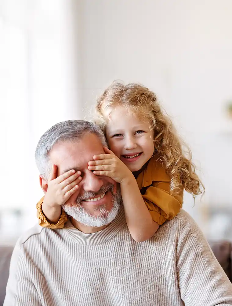 girl covering eyes her smiling grandfather