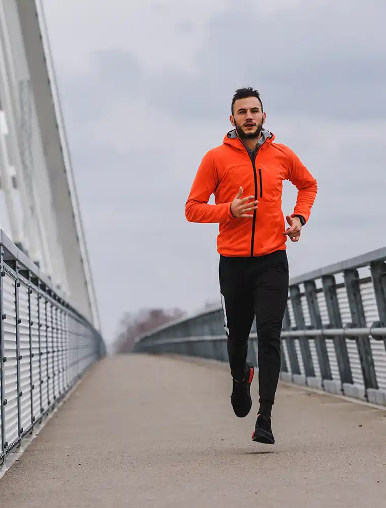 man running orange jacket heality lifestyle