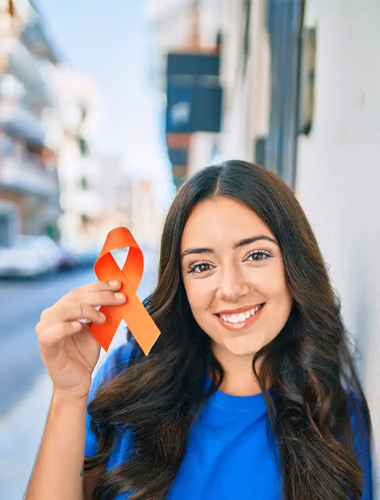woman smiling happy holding orange ribbon